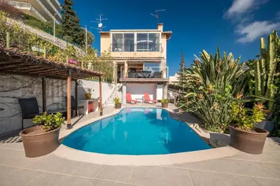 a swimming pool in front of a house at Bas de villa plus piscine Vue époustouflante in Villefranche-sur-Mer