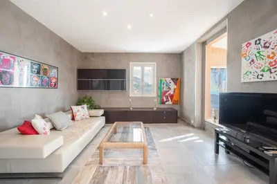 a living room with a couch and a coffee table at Bas de villa plus piscine Vue époustouflante in Villefranche-sur-Mer