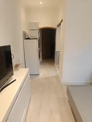 a living room with a refrigerator and a hallway at Appart in Nice