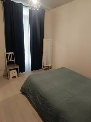 a bedroom with a bed and a chair and a window at Appart in Nice
