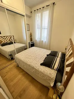 a bedroom with two beds and a mirror at T2 centre ville de Nice face de la gare routière Nice ville in Nice