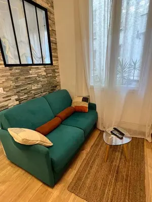 a green couch in a living room with a window at T2 centre ville de Nice face de la gare routière Nice ville in Nice