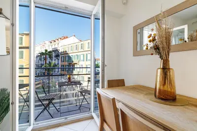 a room with a table and a balcony with a view at Nice Luxury in Nice