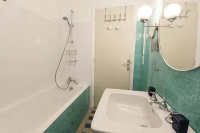 a bathroom with a sink and a tub and a mirror at Charming T1 with terrace and sea view in Nice