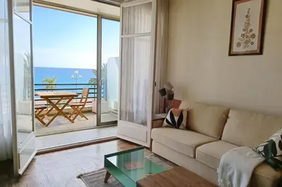a living room with a couch and a view of the ocean at Charming T1 with terrace and sea view in Nice