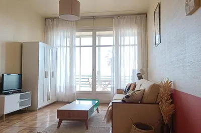 a living room with a couch and a tv at Charming T1 with terrace and sea view in Nice