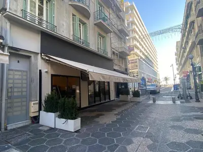 a building on a street with potted plants on the sidewalk at Cosy Studio Promenade in Nice