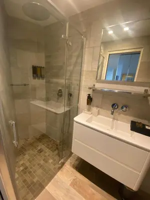a bathroom with a glass shower and a sink at Cosy Studio Promenade in Nice