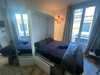 a bedroom with a mirror and a bed in a room at Cosy Studio Promenade in Nice