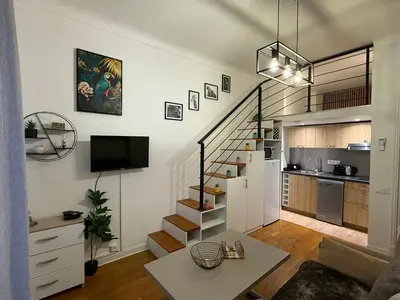 a living room with a staircase and a kitchen at Studio Sunrise - Jean Médecin in Nice