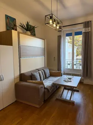 a small kitchen with wooden cabinets and a sink at Studio Sunrise - Jean Médecin in Nice