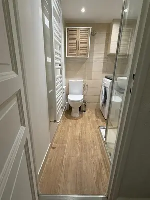 a small bathroom with a toilet and a glass door at Studio Sunrise - Jean Médecin in Nice