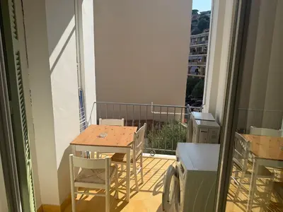 a small balcony with a table and chairs on a balcony at Appartement 3 pièces 5 min plage in Beaulieu-sur-Mer