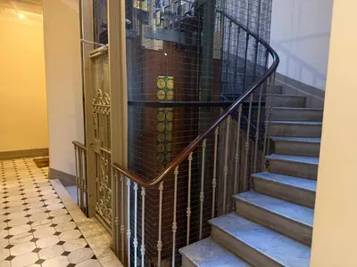a staircase in a building with a wrought iron railing at Appartement 3 pièces 5 min plage in Beaulieu-sur-Mer