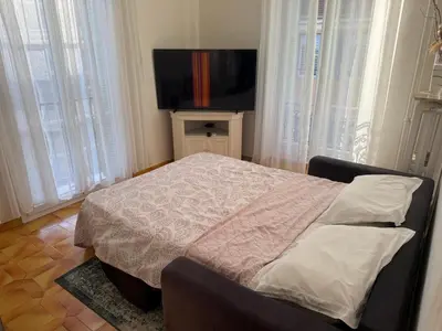 a bedroom with a bed and a flat screen tv at Appartement 3 pièces 5 min plage in Beaulieu-sur-Mer