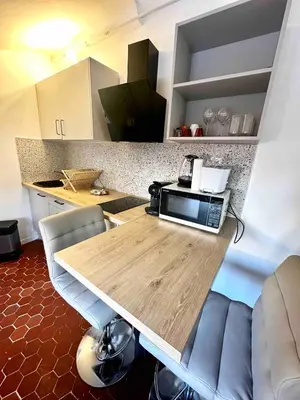 a kitchen with a table with a microwave on it at Charmant studio Vieux Nice in Nice