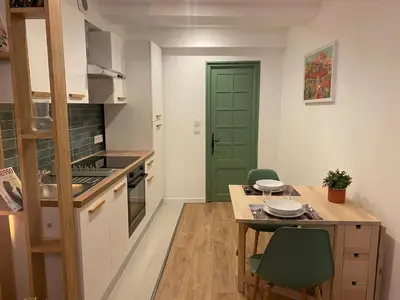 a kitchen with a table and a green door at Cosy Appartement Vieux Nice in Nice
