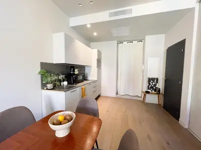 a kitchen and dining room with a wooden table and chairs at Appartement cozy au coeur de Nice in Nice