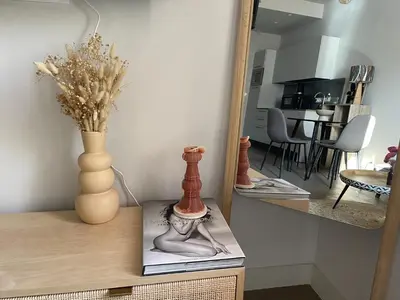 a table with a vase and a mirror on it at Appartement cozy au coeur de Nice in Nice