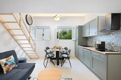 a kitchen and living room with a table and chairs at Bleu Rivage - Magnifique 2P au Port de Nice - 1 chambre et 1 Mezzanine in Nice