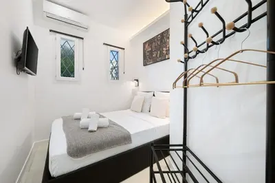 a white bedroom with a bed and a tv at Bleu Rivage - Magnifique 2P au Port de Nice - 1 chambre et 1 Mezzanine in Nice