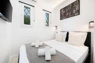 a white bedroom with a bed with towels on it at Bleu Rivage - Magnifique 2P au Port de Nice - 1 chambre et 1 Mezzanine in Nice