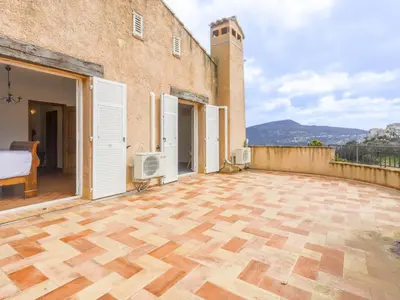 an outdoor patio with wooden flooring and white doors at Holiday Home Le Mas de Gattières by Interhome in Gattières