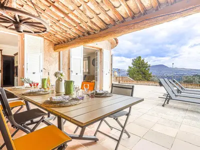 a dining room with a table and chairs on a patio at Holiday Home Le Mas de Gattières by Interhome in Gattières