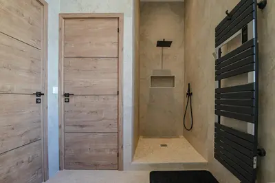 a shower with a wooden door in a bathroom at Massena Infinity in Nice