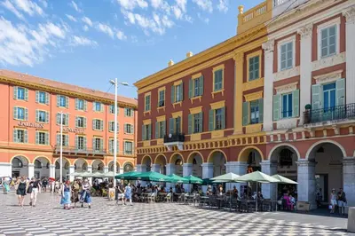 a group of people walking in a plaza in front of buildings at Massena Infinity in Nice