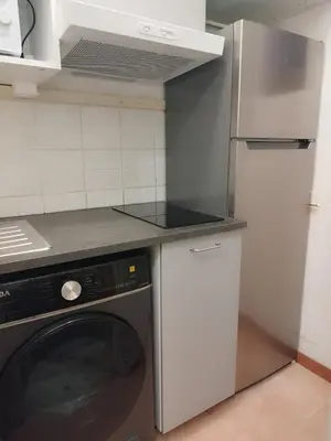 a kitchen with a washing machine and a refrigerator at L'escale Azurienne in Nice