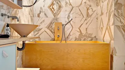 a bathroom with a wooden tub and a sink at Palm & Sun in Nice