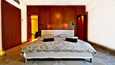 a bedroom with a large bed with wooden walls at Palm & Sun in Nice