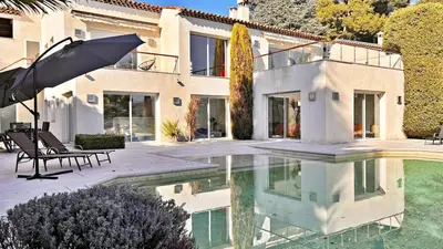 a house with a swimming pool and an umbrella at Palm & Sun in Nice