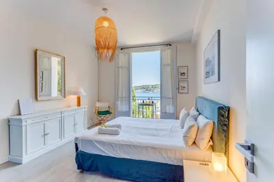a bedroom with a bed with a view of the ocean at BELLE DARSE AP4454 By Riviera Holiday Homes in Villefranche-sur-Mer