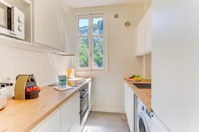 a kitchen with white cabinets and a window at BELLE DARSE AP4454 By Riviera Holiday Homes in Villefranche-sur-Mer