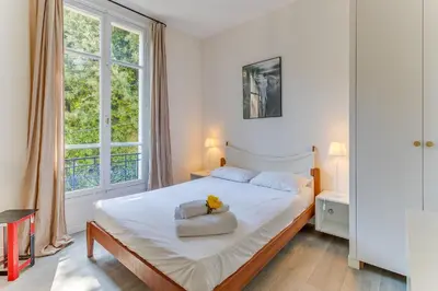 a bedroom with a large bed with a white bedspread at BELLE DARSE AP4454 By Riviera Holiday Homes in Villefranche-sur-Mer