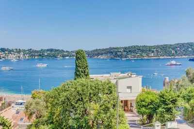 a tree on top of a building next to a body of water at BELLE DARSE AP4454 By Riviera Holiday Homes in Villefranche-sur-Mer