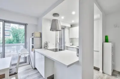 a white kitchen with a sink and a refrigerator at Flat with balcony 15min from Promenade des Anglais in Nice