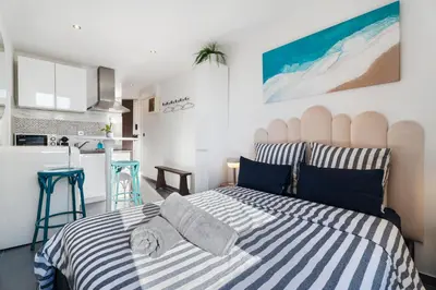 a bedroom with a bed with blue and white stripes at Cocon Place Massena, Cours Saleya et Mer in Nice