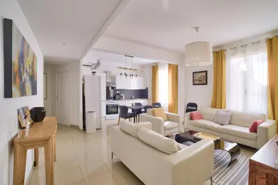 a living room with white furniture and a kitchen at Stunning 2BR by the Port 20min Walk to the Beach in Nice