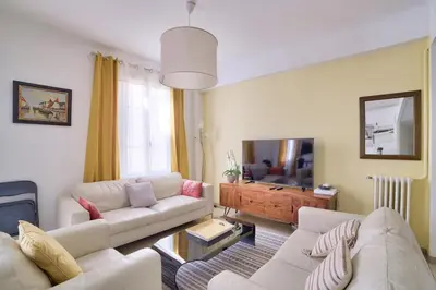 a living room with two white couches and a television at Stunning 2BR by the Port 20min Walk to the Beach in Nice