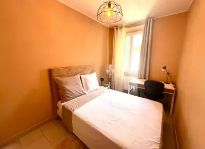 a bedroom with a bed and a desk and a window at Residence Lascaris in Nice