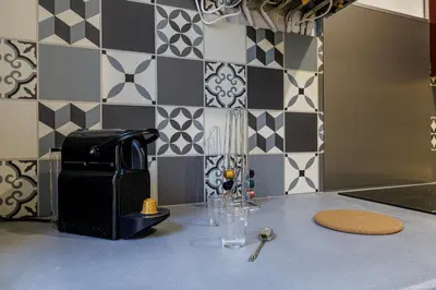 a kitchen with a counter with a table with a drink at 36 STALNGRAD - Appartement spacieux - Le Port - 6 pers in Nice
