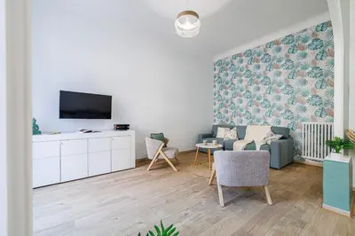 a living room with a tv and a couch and chairs at 36 STALNGRAD - Appartement spacieux - Le Port - 6 pers in Nice