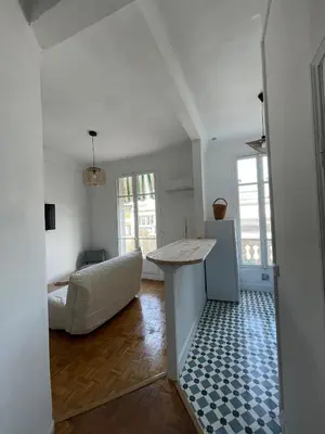 a kitchen and living room with a table and a couch at Appartement Nice Centre Palais OPHELIA in Nice