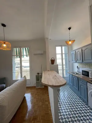 a kitchen with a table in the middle of a room at Appartement Nice Centre Palais OPHELIA in Nice