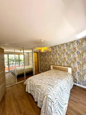 a bedroom with a large bed and a large window at Superbe appartement 2 pièces avec piscine in Nice