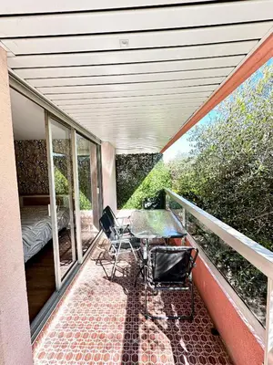 a balcony of a house with a table and chairs at Superbe appartement 2 pièces avec piscine in Nice