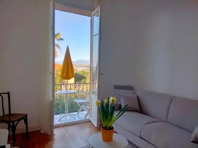 a living room with a couch and a balcony at L'Essentiel à Nice in Nice
